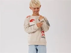 Dreng klædt i beige sweatshirt med sort, rødt og hvidt print og broderi fra Name It 13244172 peyote